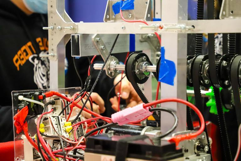 A student works on his robot's wiring at Kettering University.